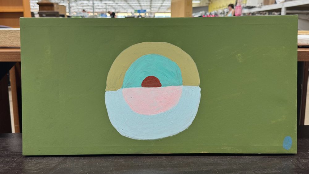 A thrift store painting of a central bisected disc with five concentric arcs in baby blue, pink, beige, turquoise, and burgundy on an olive green field, with a royal blue dot in the lower right corner. 