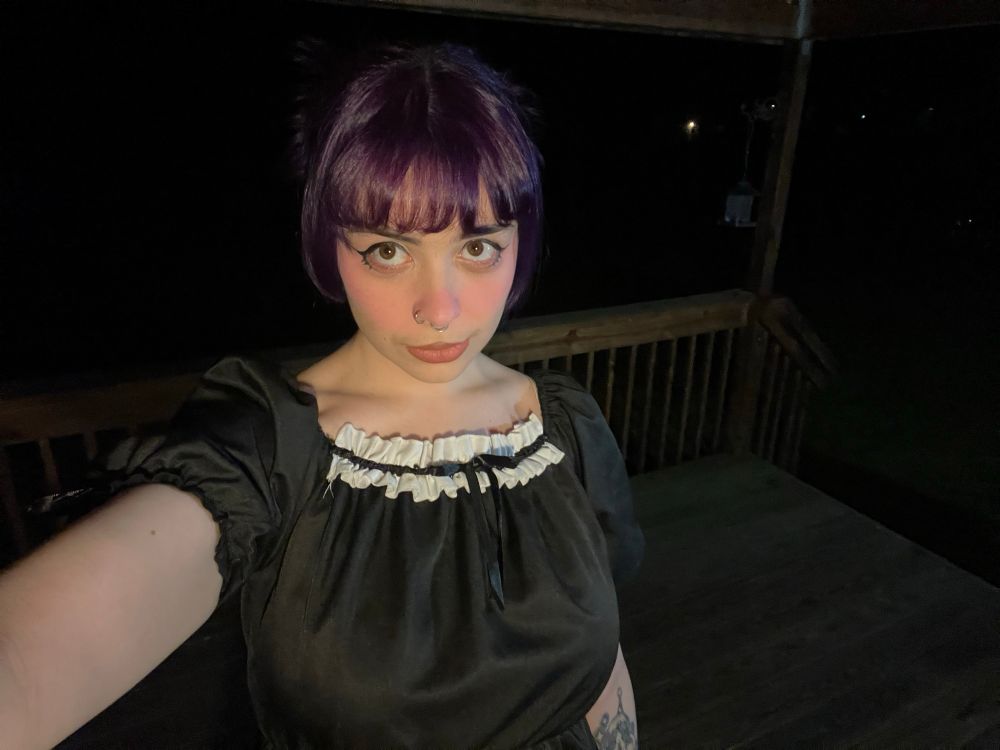 a selfie of bunni in a black dress with white ruffle detailing