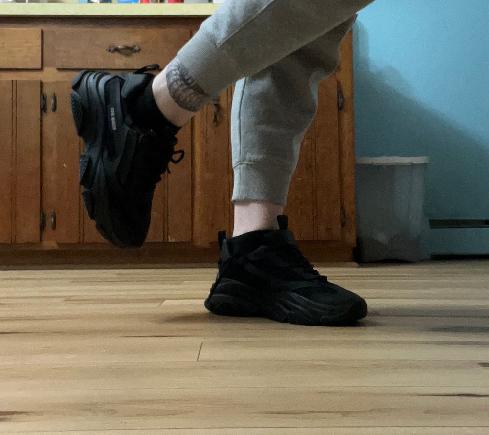 a picture of Bunni in black chunky sneakers with one leg up (they are steve madden possession) 
