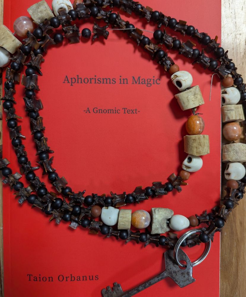 Red Book cover of Aphorisms in Magic
A gnomic text, by Taion Orbanus Edited by Sarah O Garcia, with a snake bone mala and key
