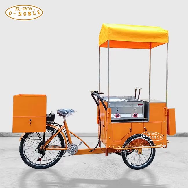 an orange tricycle with a canopied vending compartment over the front 2 wheels. 