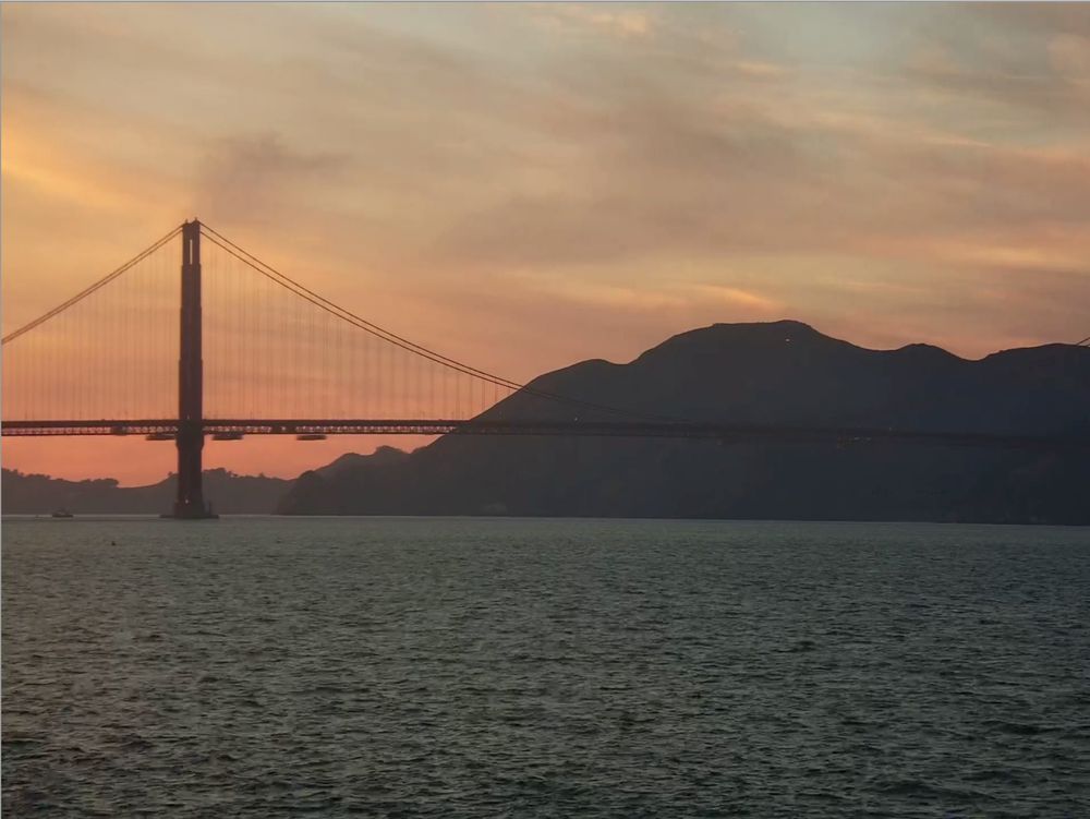 view of the golden gate bridge and headlands from crissy field at sunset