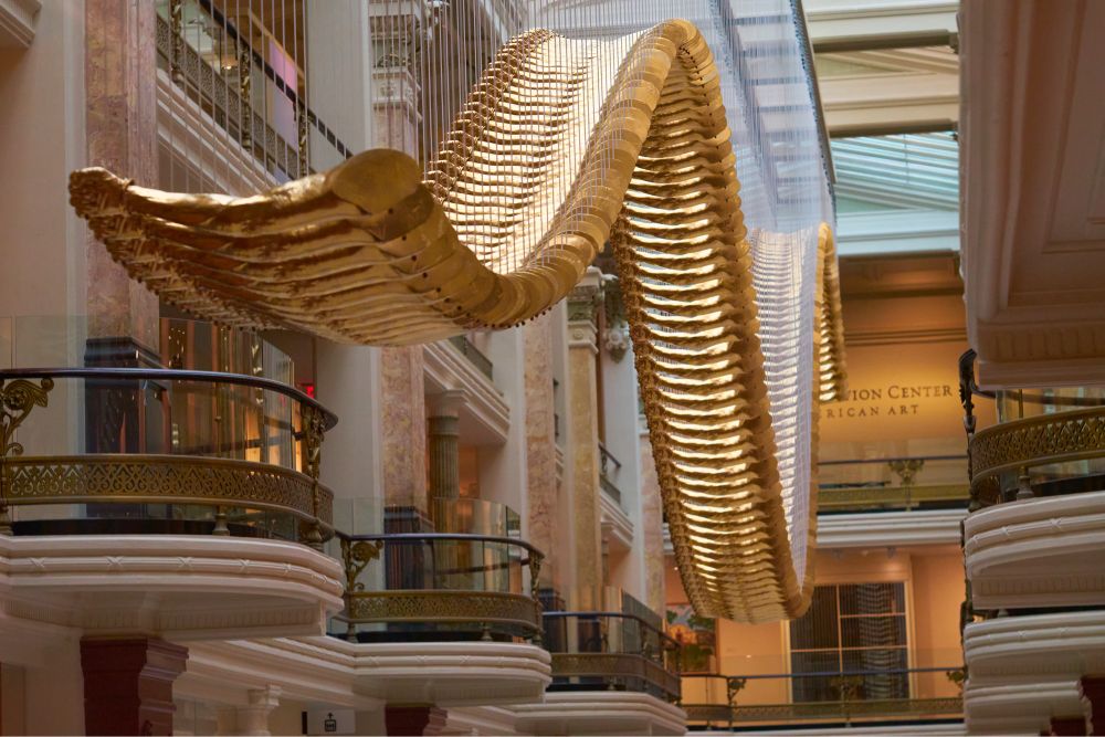 What appears to be a footbridge snaking through the ceiling of the Luce Center. Upon closer inspection, the slats are gold painted fiberglass made from a cast of 1968 Olympian Tommie Smith’s arm with a clenched fist