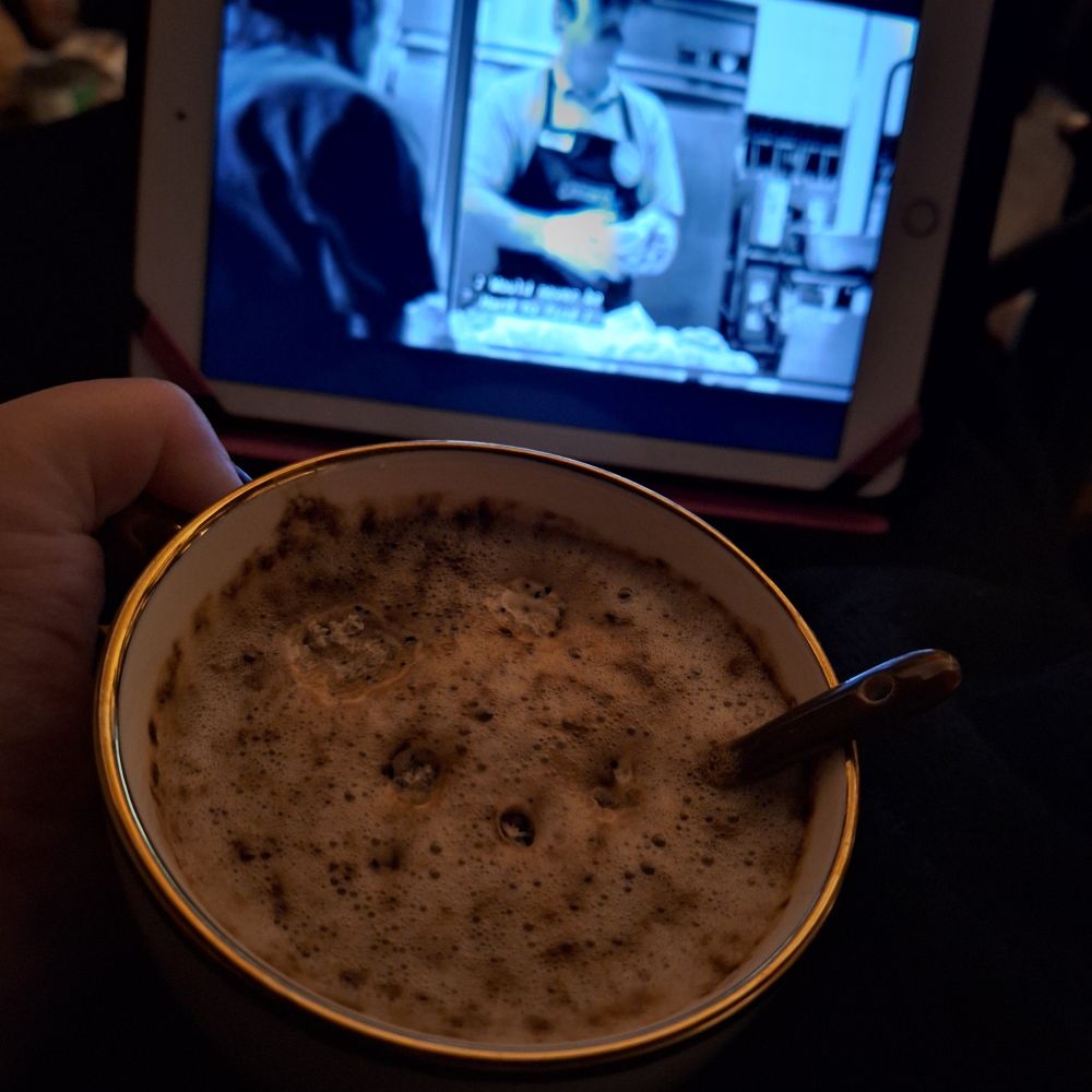 Moss' cappucino mug while their ipad is playing Better Call Saul