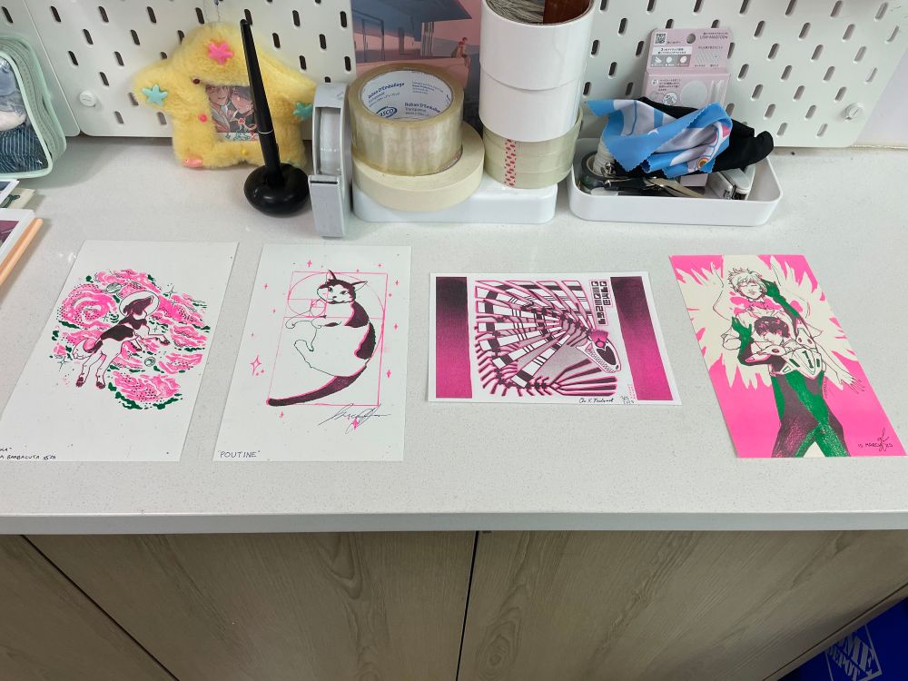 Four pink and green risograph prints featuring Laika the space dog, a cow print cat, a fish creature from Phantomarine web comic, and Shinji and Kaworu from Neon Genesis Evangelion.