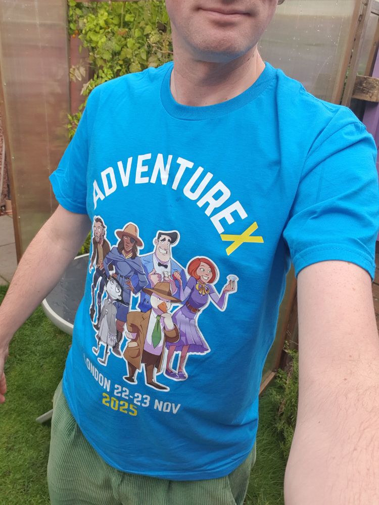 Someone wearing a blue t-shirt, with AdventureX written on it, and great illustrations from 6 recent adventure games