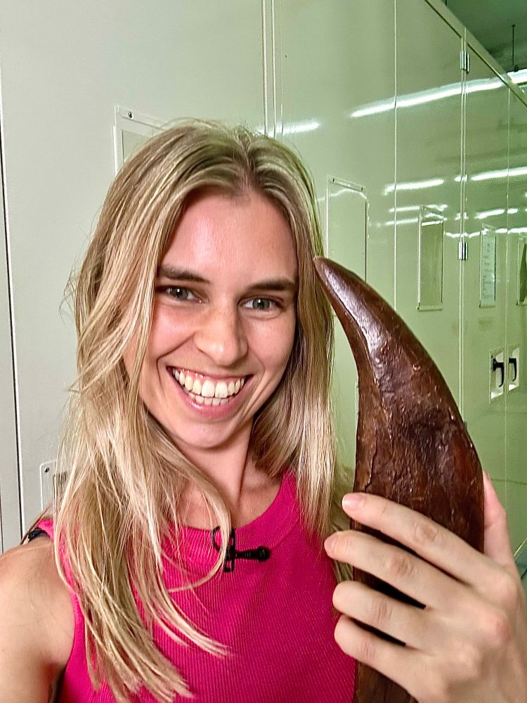 Emma holding a replica T.rex tooth.