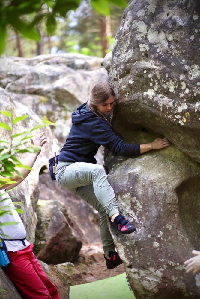 Emma climbing a boulder in Fontainebleau