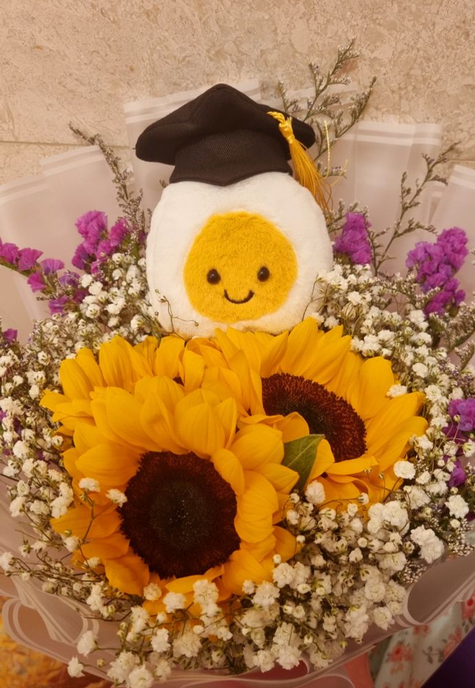 Graduation bouquet I received from my parents that's topped with an egg plush with a graduation cap