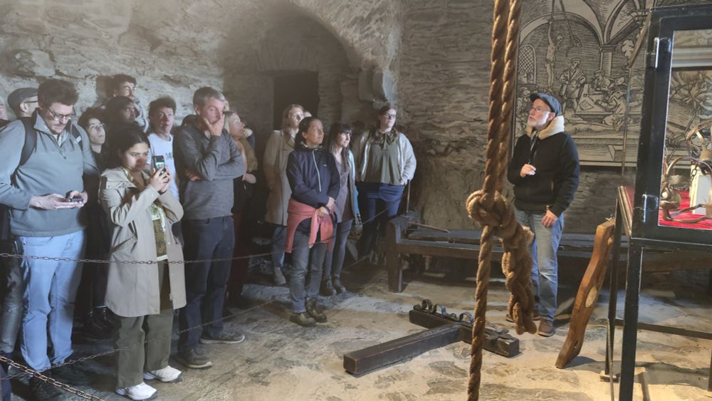 A group of scientists having a guided tour of a mediaeval castle