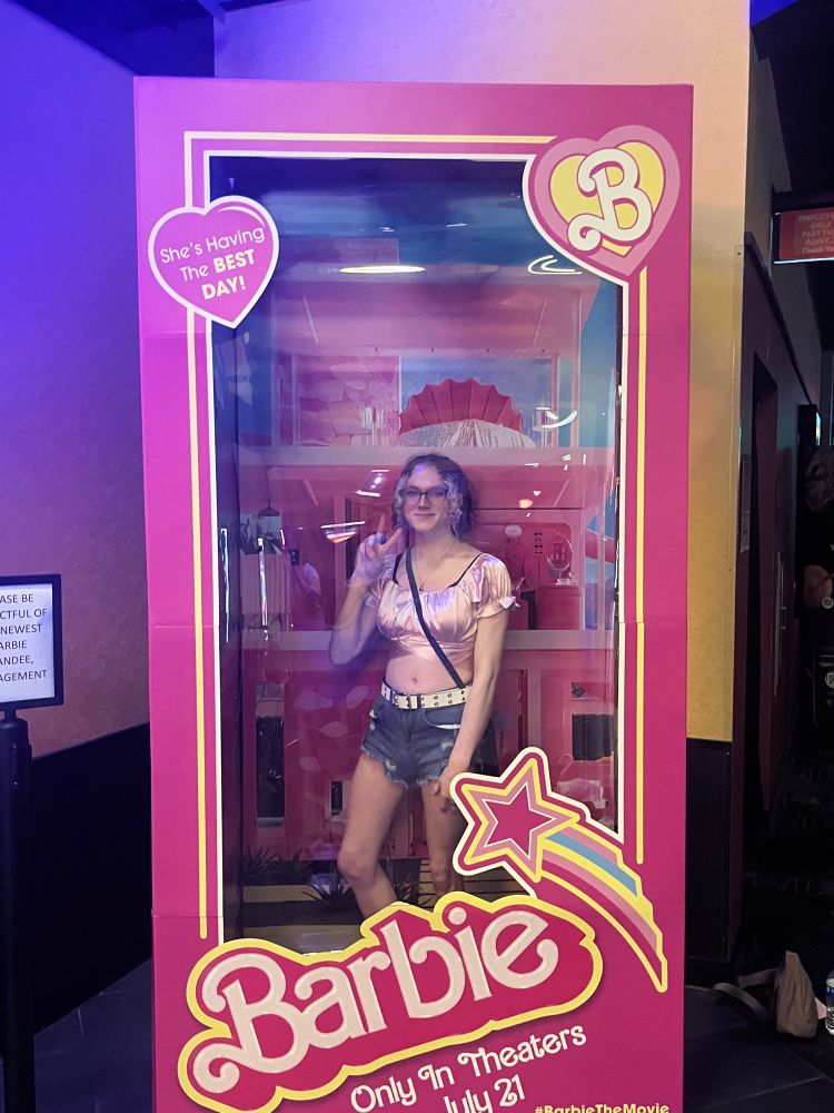picture of a gorgeous girl in a live size barbie doll box. she’s wearing a satin pink crop top, blue cutoff jean short shorts with a white belt, and a black cross body it’s bag. she’s holding up a peace sign and smiling with glee holding her left leg slightly bent.

luv yuuu <3<3