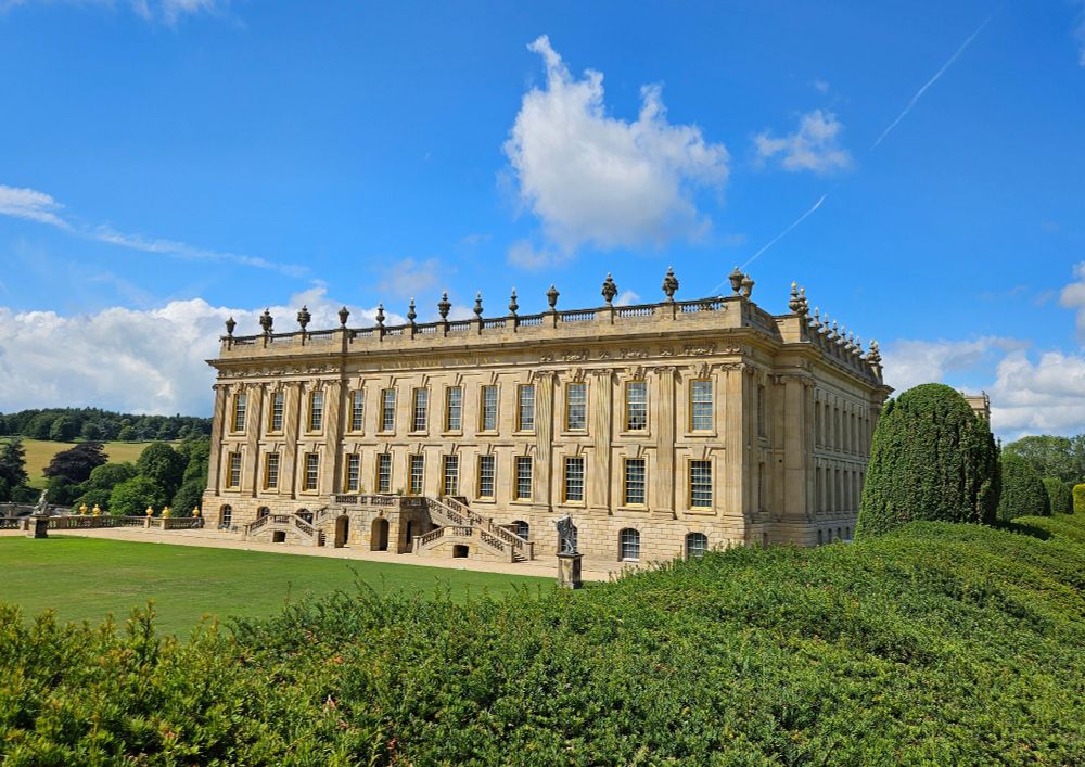 Chatsworth House with a hedge in the foreground 