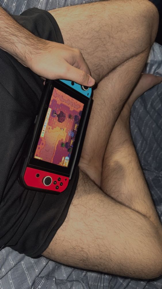 legs crossed and playing stardew valley on a nintendo switch, clearly purposefully showing thighs 
