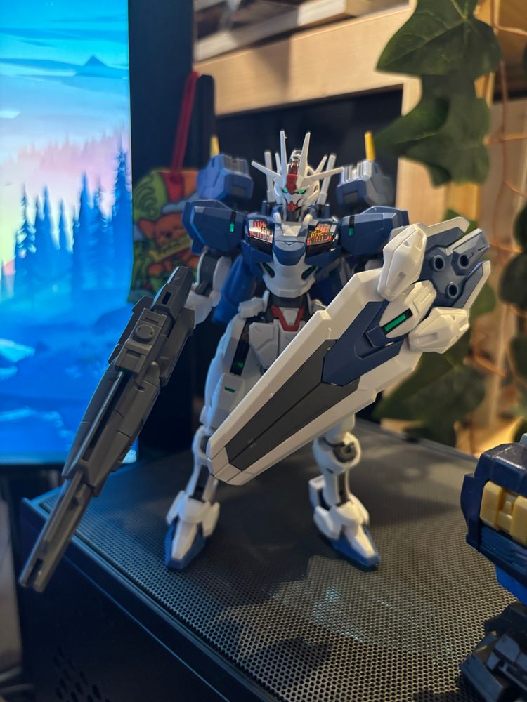 Fully built HG Gundam Aerial Rebuild gunpla model, holding a shield and a gun.
