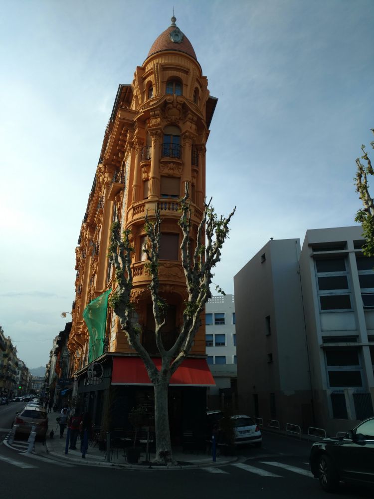 Nice France old colorful narrow building among more modern Brutalist buildings