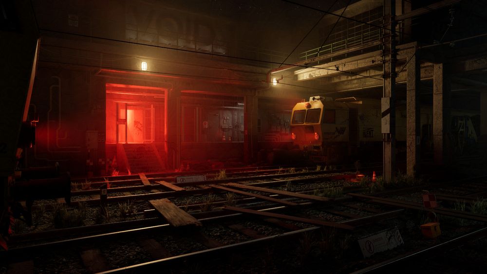 The Image represents a night scene of a railway besides a station or warehouse entrance. Said entrance is glowing red and the train on the right side is lit in a warm yellow. 