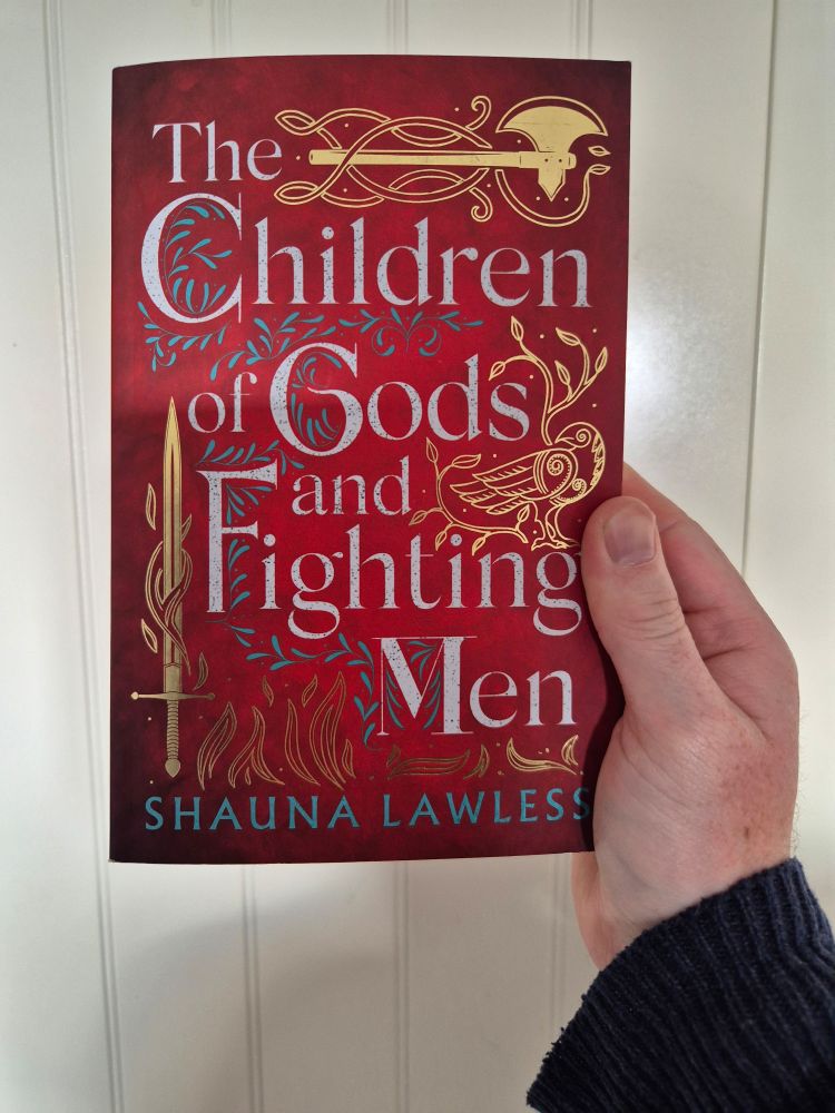 An axe at the top, a bird tl the right and a sword to the left, with leaves around. All in gold on a red background. 