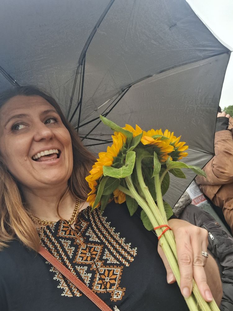 Andrea Chalupa (me) holding sunflowers at the no kings march)