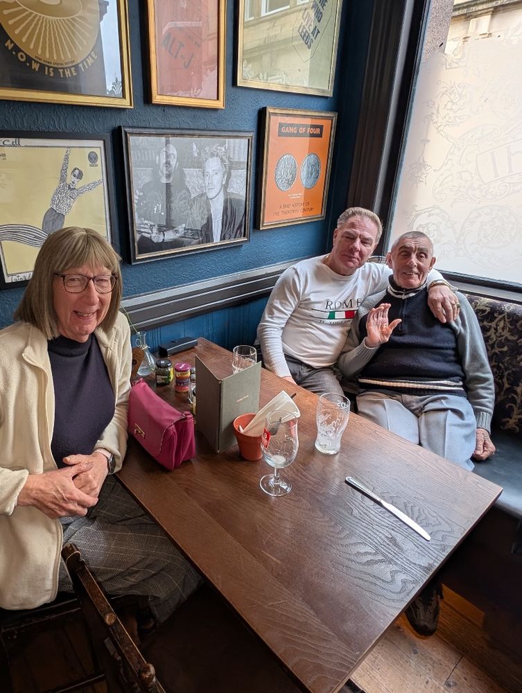 1 woman 2 men at a table in apub