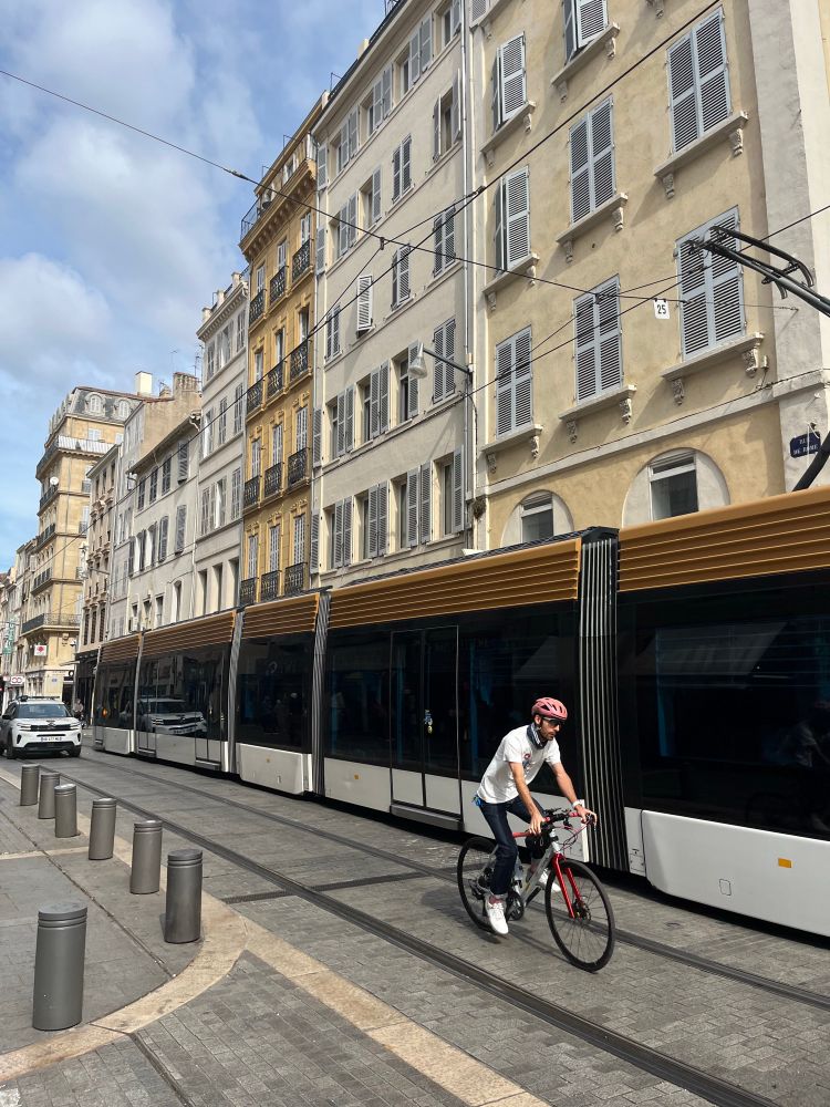 marseille tramway, rue de la rome, with cyclist next to the tram