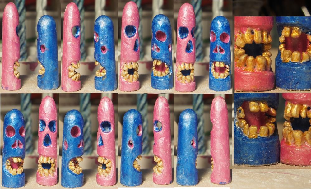 The same two monsters, but they have been painted. One is a metallic pink on the outside, blue inside. The other has the same colours inverted. Both have gold teeth.