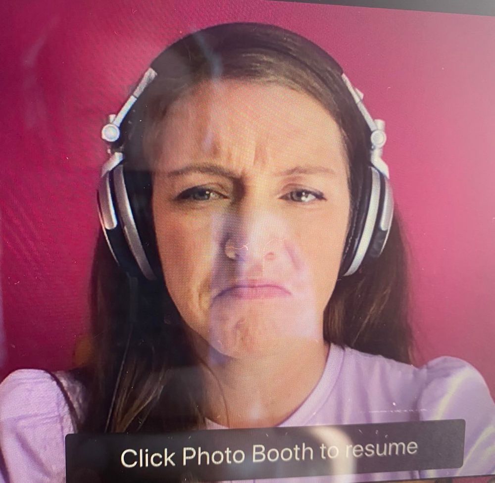 An unfortunate Photo Booth picture of me frowning with headphones on 