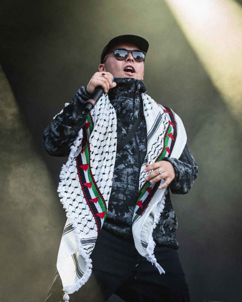 Rapper from Irish group Kneecap wearing a keffiyeh on stage at Øyafestivalen in Oslo.