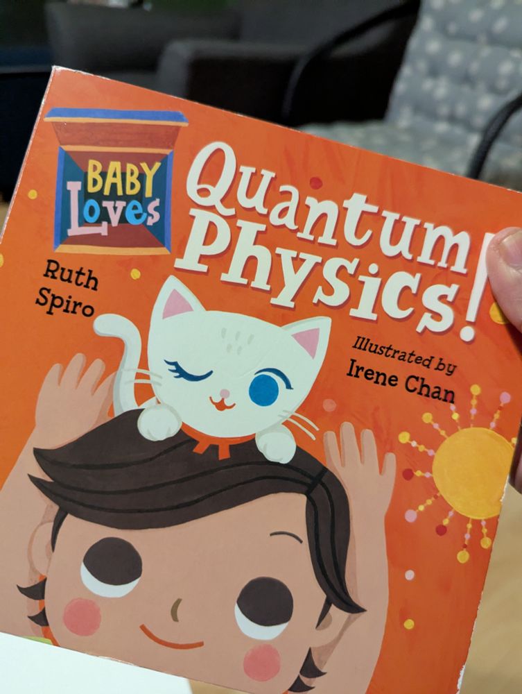 Cover of Baby Loves Quantum Physics by Ruth Spiro and Irene Chan. An orange cover with a graphic style baby and a white cat on their head. The cat is winking, and has a red bow around it's neck.