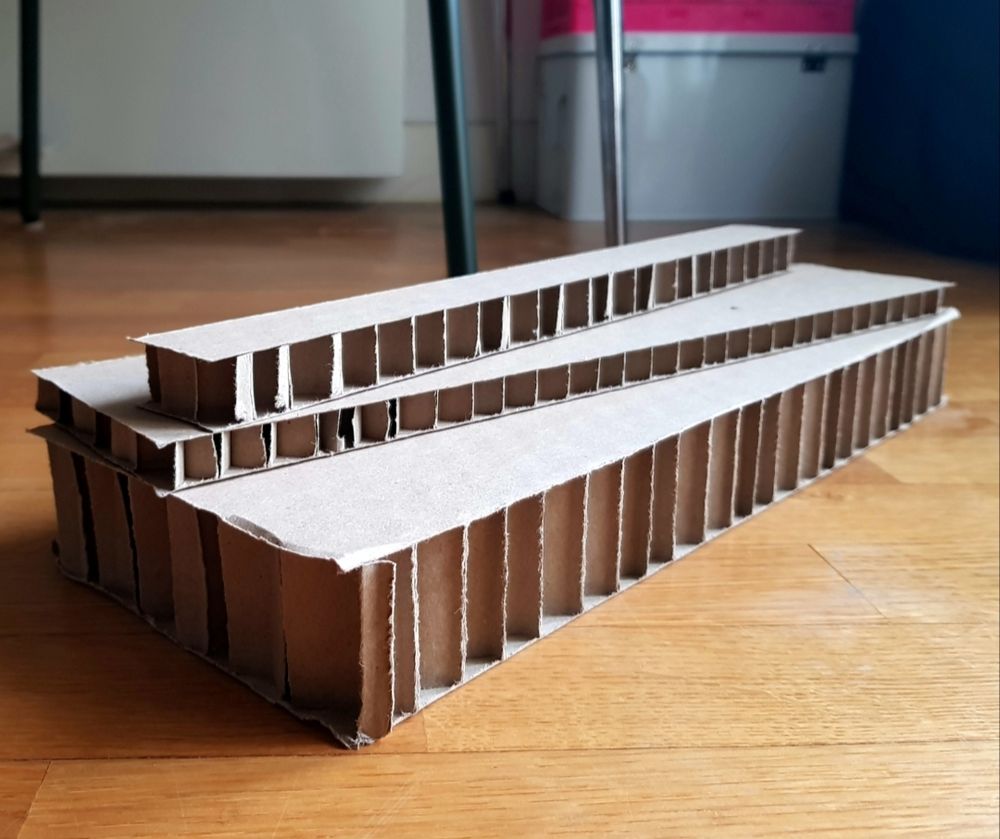 Trois bouts de cartons posés l'un sur l'autre formant une architecture brutaliste.