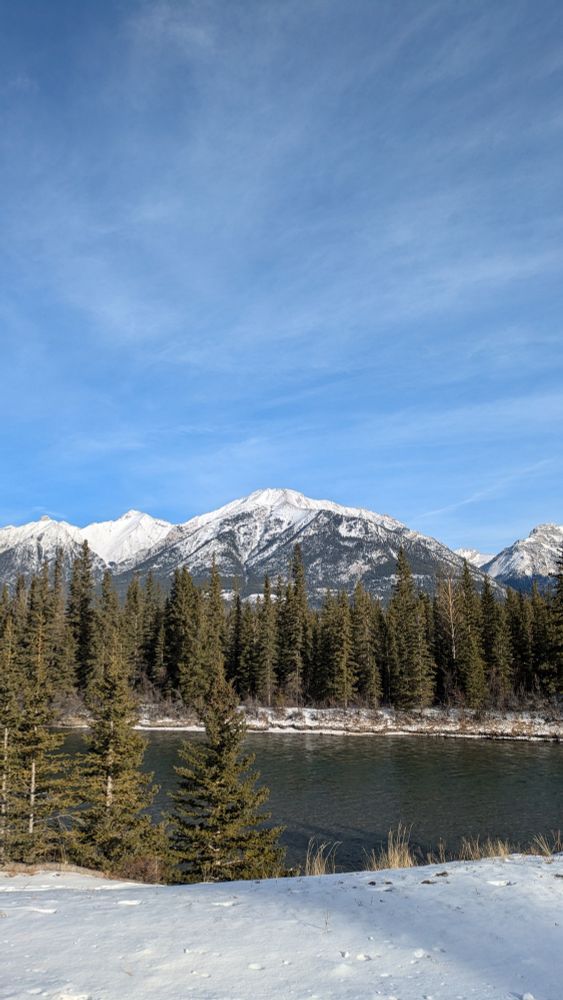 Blue skies with snowy mountains and a river