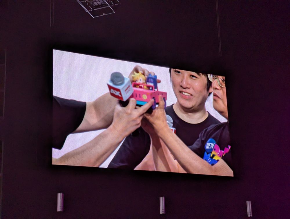 Imaishi holding a model of the car