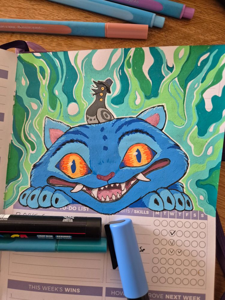 A green and blue picture.  Blue Tiger looking up from a weekly planer Page with a  magpie on his head
