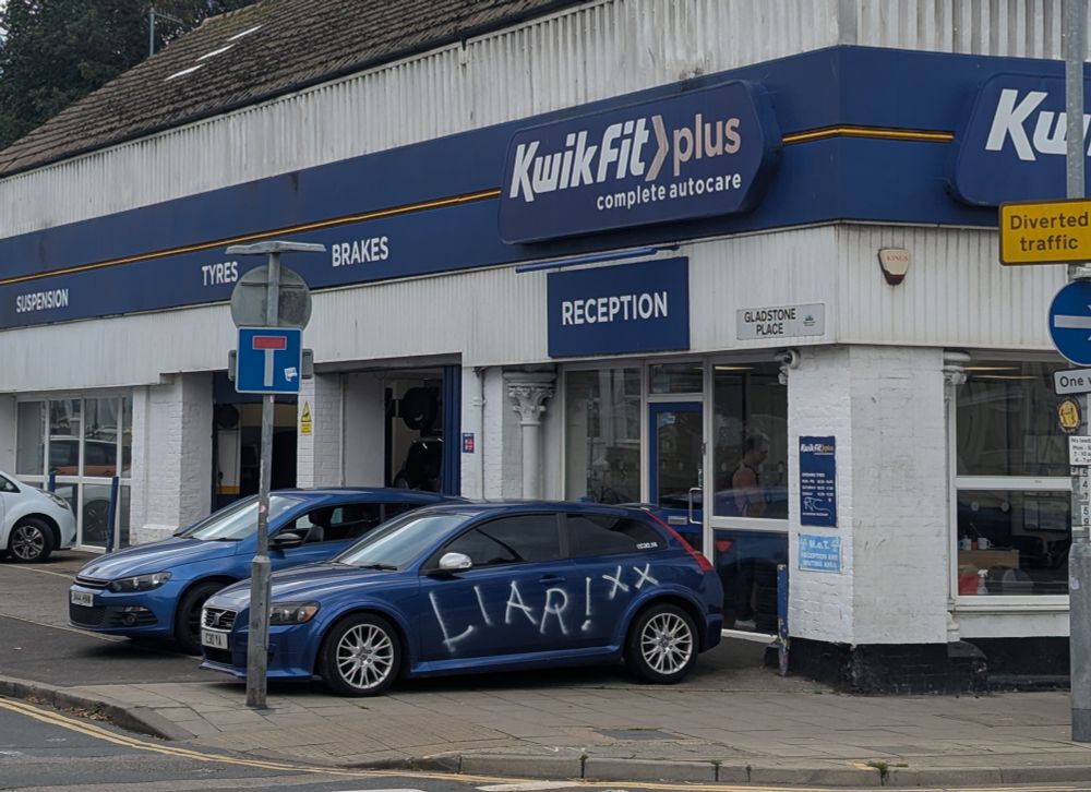 The word "liar" is sprayed over a car