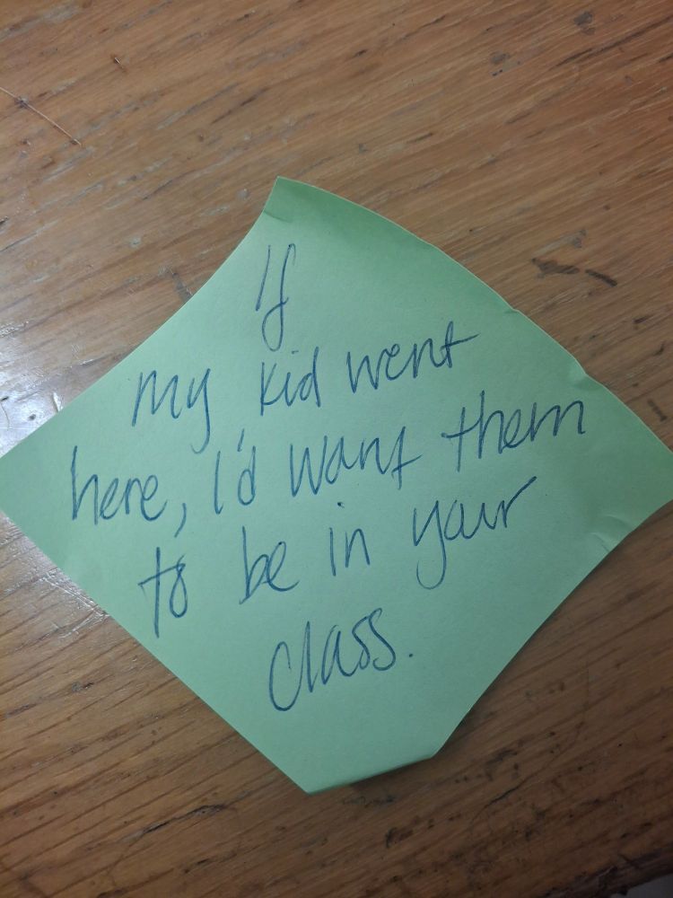 A post it note, with writing on it saying "If my kid went here, I'd want them to be in your class."