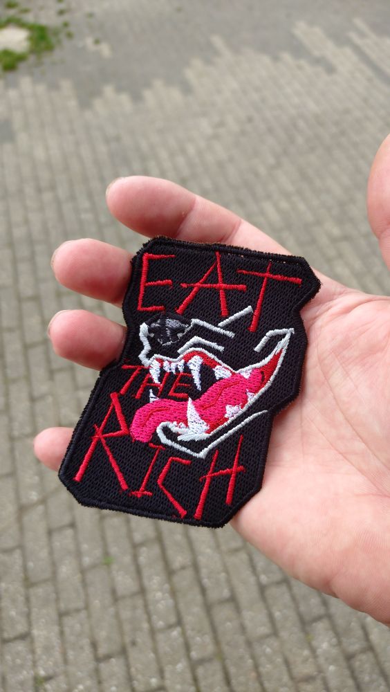 Patch displaying an open maw with the tekst "eat the rich"