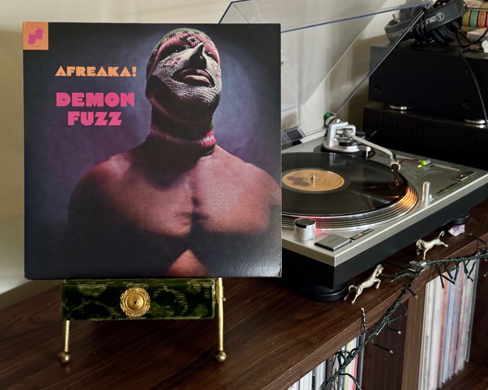 Vinyl copy of Demon Fuzz's album "Afreaka!" sitting on a velvet Victorian photo stand. The record plays on a turntable beside it.


#nowplaying
#fusion
#psychedelicsoul