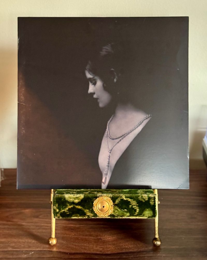 Vinyl sleeve of The Limiñanas "Crystal Anis" album sitting on a velvet Victorian photo stand.