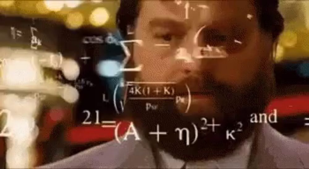 a man with a beard is looking at a computer screen with mathematical equations coming out of it .