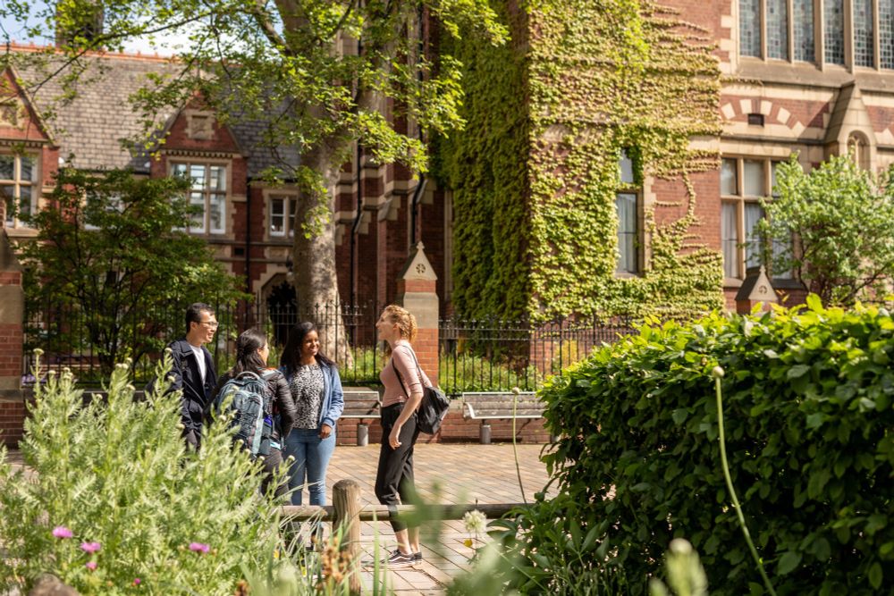 Four students talk in front of the Great Hall