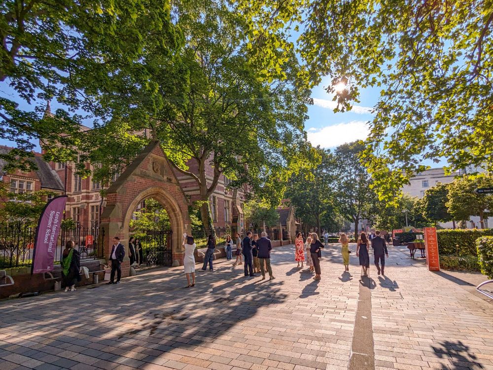 People in smart clothes and graduation gowns stood outside the Clothworker's Court archway.