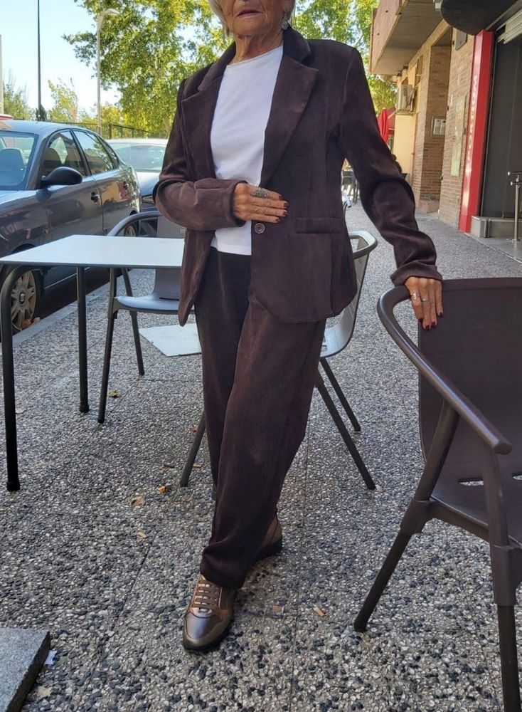 My grandma, Feli, wearing a brown two piece suit and shoes over a white blouse.