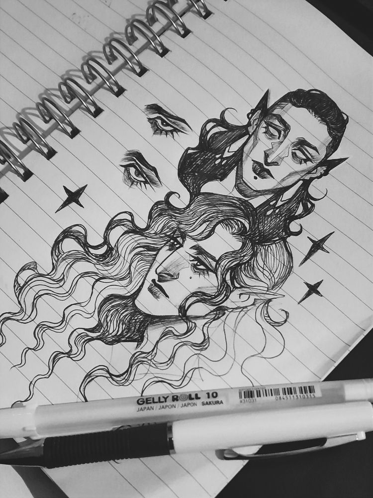 Some freehand notebook doodles of character faces, drawn with a ballpoint pen