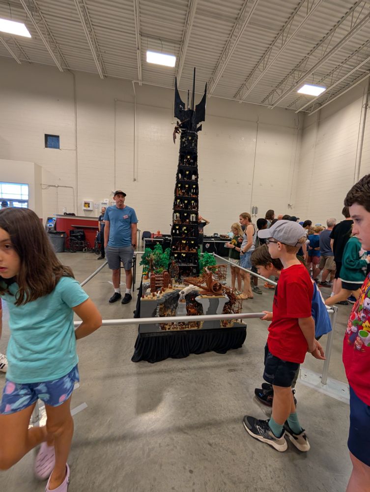 An insanely tall model of Orthanc (from The Lord of the Rings), built by Brendan McMahon of Columbus, Ohio. (That's him in the blue shirt.) It's super detailed—you can see the machines and scaffolding underground where the orcs are building weapons of war; the Ents carrying hobbits; an eagle at the top of the tower rescuing Gandalf; et very much cetera. Zoom in if you dare.
