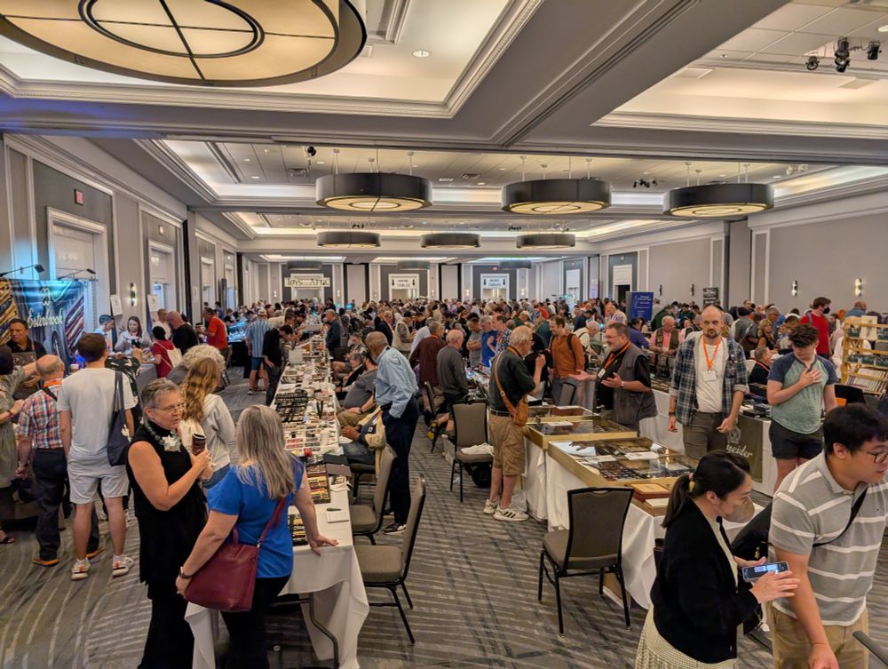 View of the biggest room (out of four or five, or even six depending on whether you count the packed hallways) at the D.C. Fountain Pen Supershow in Falls Church, Virginia on August 2, 2025. People milling around looking at pens.