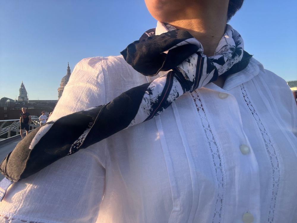 Girl in white dress and black and white silk scarf draped around the neck 