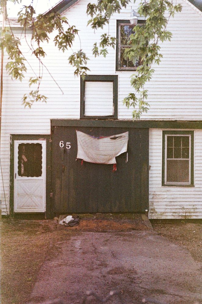 A barn door with a tattered American flag shot on expired Fuji superia 400 film.