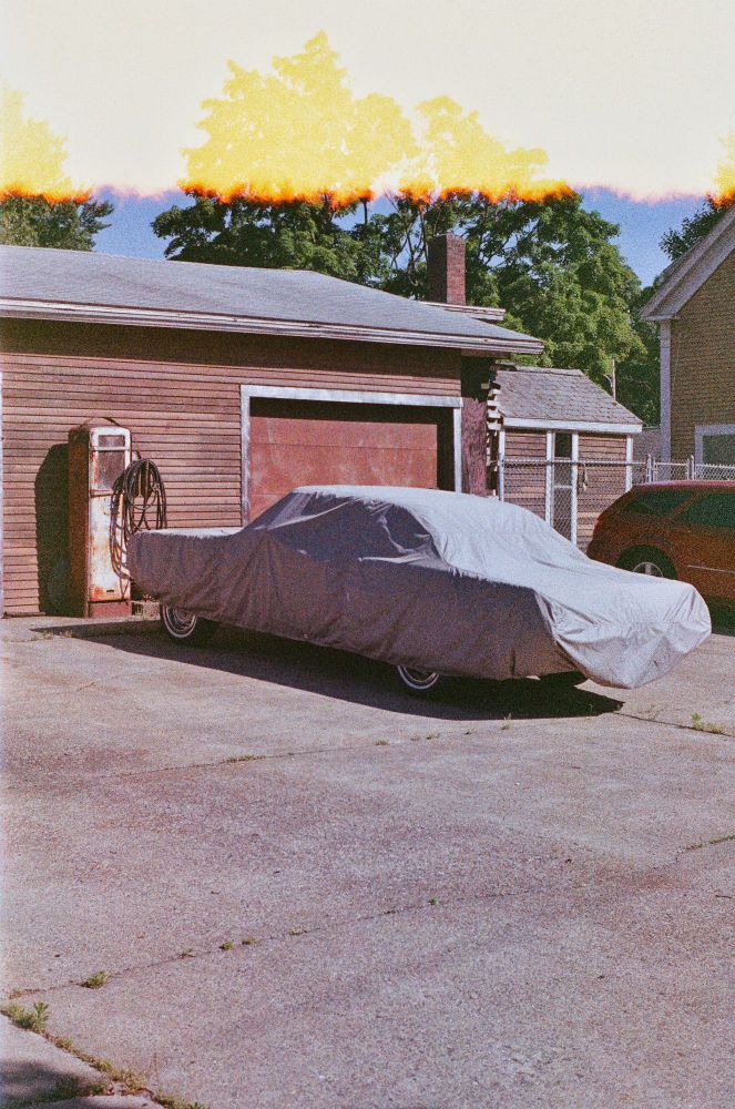 An old car under a cover shot on expired Fuji superia 400 film.