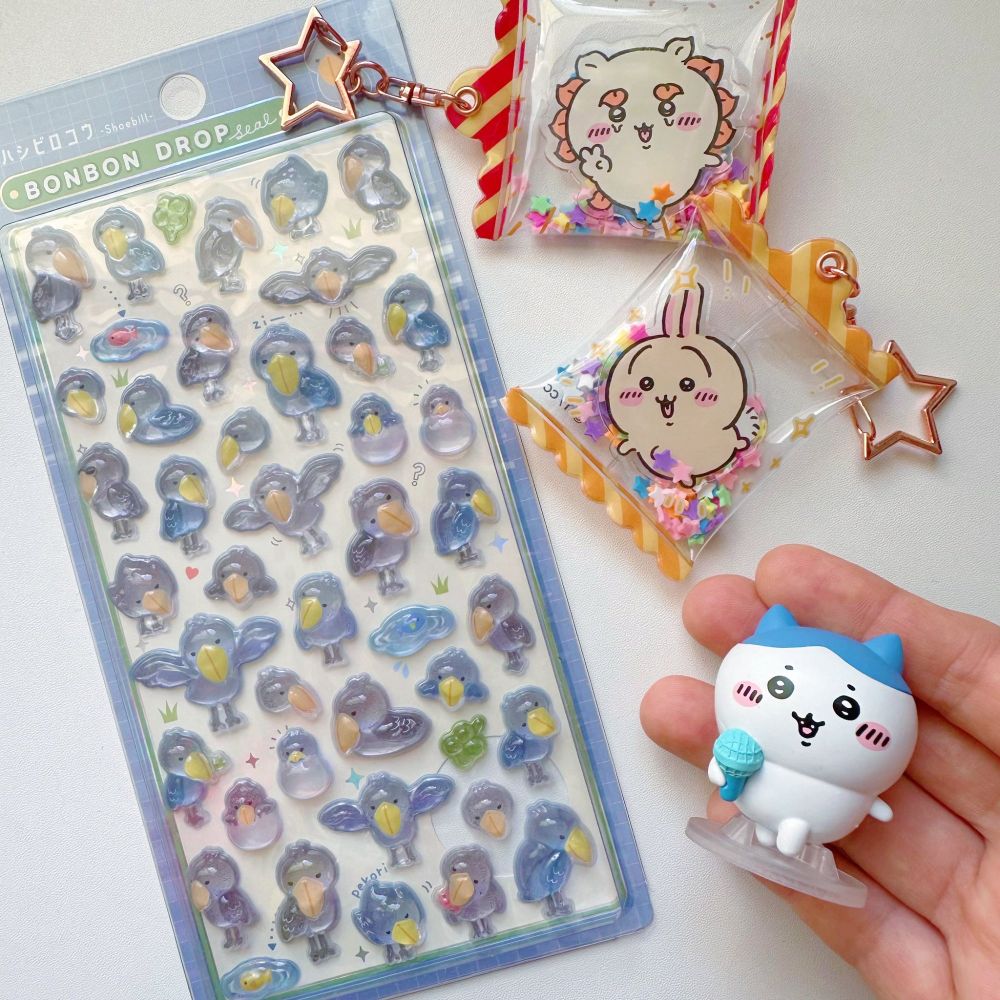 a sheet of shoebill stickers, two candy style chiikawa keychains and a figure of hachiware.