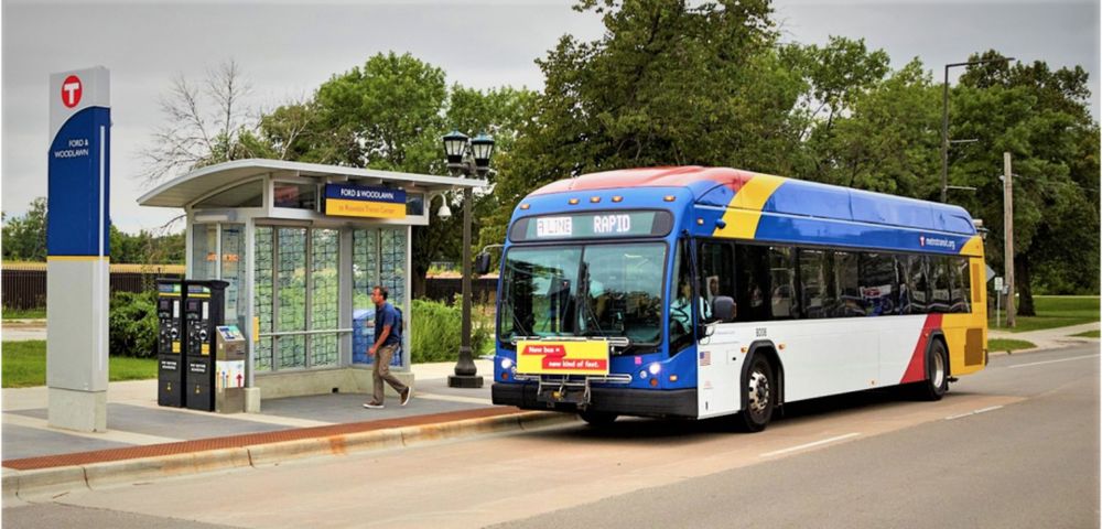 A colorful yellow, red, blue and white BRT bus at a station