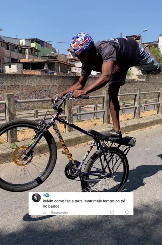 Print de um tiktok que mostra um rapaz dando grau com o pé no selim da bicicleta em resposta a pergunta de um segudor "Kelvin como faz pra levar mais tempo no pé do banco"